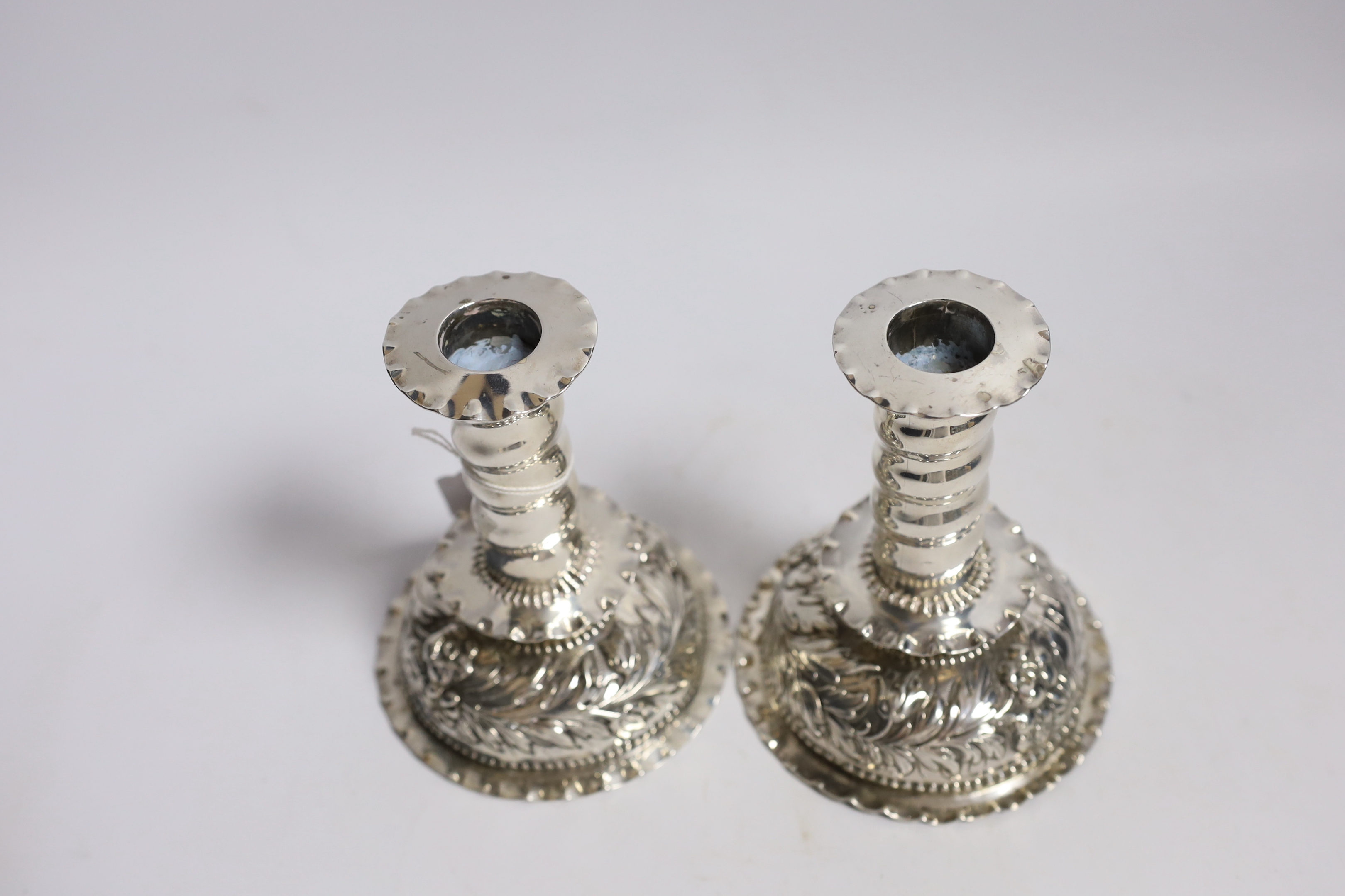 A matched pair of Carolean style silver dwarf candlesticks, London, 1880 & 1885, makers mark on one for George Fox, silver disc to base marked for Charles Stuart Harris, height 12.3cm, weighted.